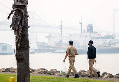 Two students walking with TSGB in background